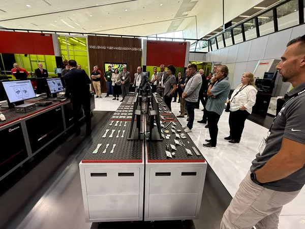 Visiteurs examinant des pièces soudées échantillons sur la table de démonstration