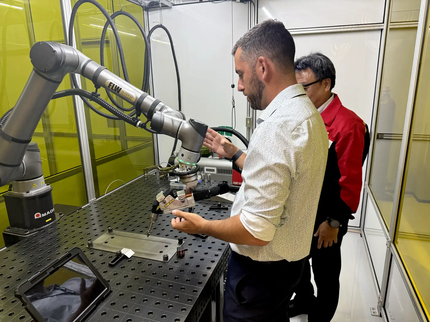 AMADA application engineer demonstrating the collaborative robot welding cell